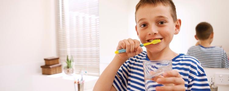 A young boy brushing his teeth.