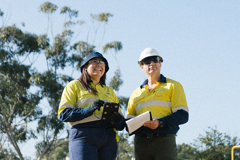 Watercoporation employees a man and a woman standing next to each other