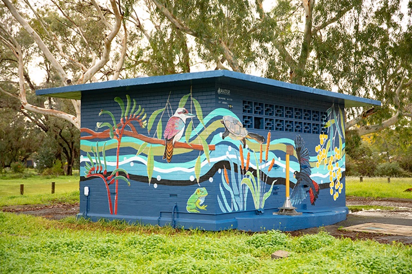 An operational asset painted with a dark blue mural featuring birds, turtles and native plants