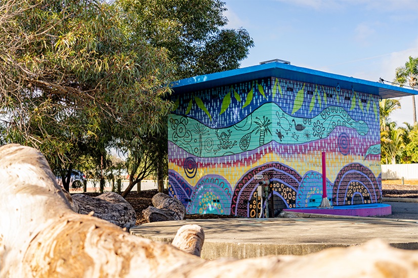 An operational asset painted with a blue, green, purple and yellow mural of the waugal