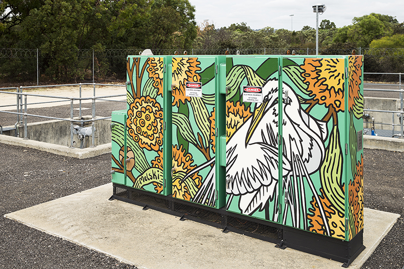 An operational asset painted with a bright mural of a white bird and orange flowers