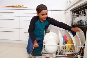 Photo of a child loading a dishwasher