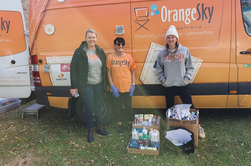 Gemma outside Orange Sky van with other volunteers