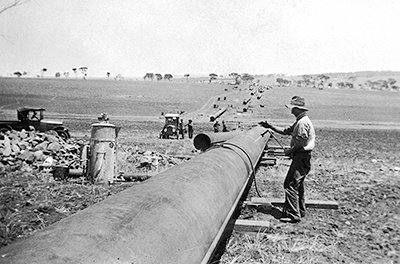 Welding pipes on the historic Goldfields pipeline, circa 1930 to 1940