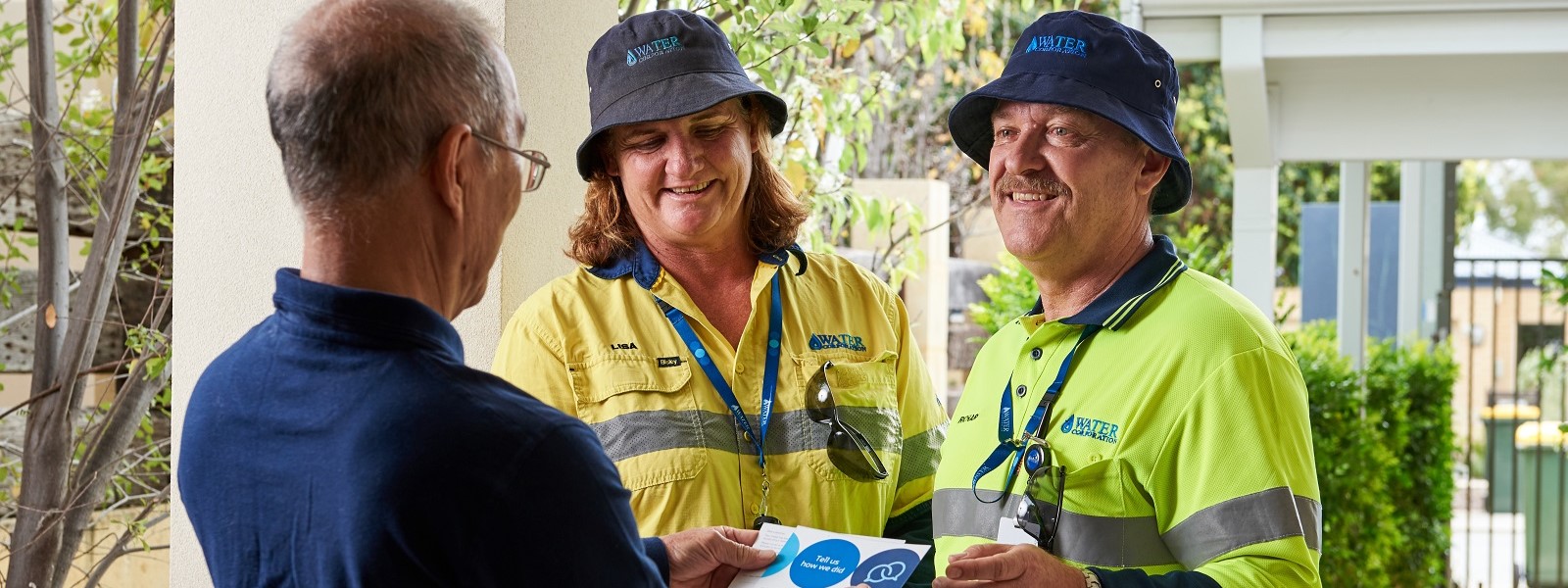 Two Water Corporation staff greet a customer at their home