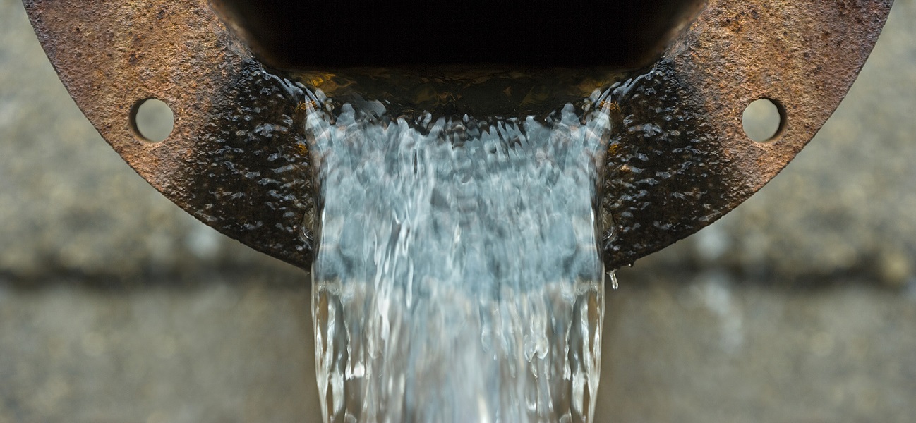A wastewater pipe with water flowing out of it