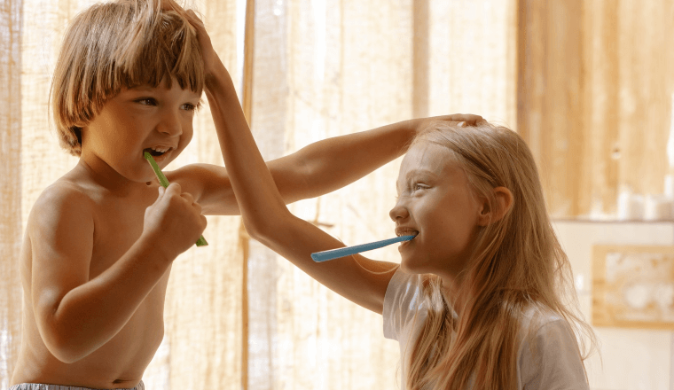 Siblings brushing their teeth