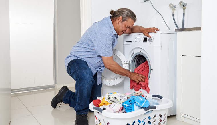 Man unloading laundry from front loader washing machine