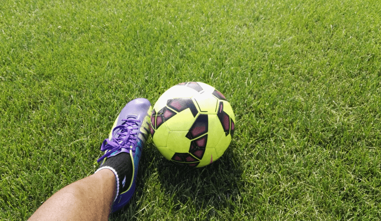 Kicking a soccer ball on the grass