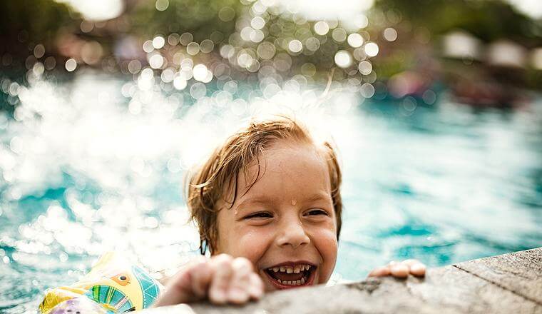 Boy smiling in a swimming pool