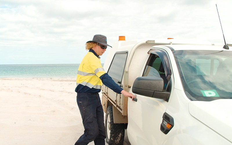 Izaiha, trainee turned drainage operator getting into the car at the site