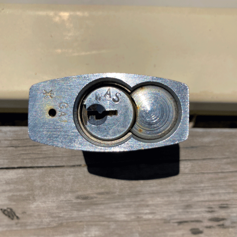 A Western Australian Services (WAS) padlock. 'WAS' is engraved on the bottom of the padlock.