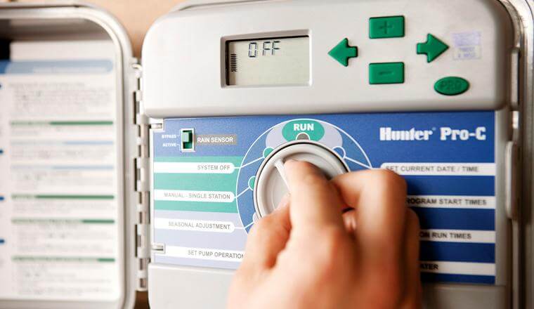 Close up of an irrigation controller - person turning the dial