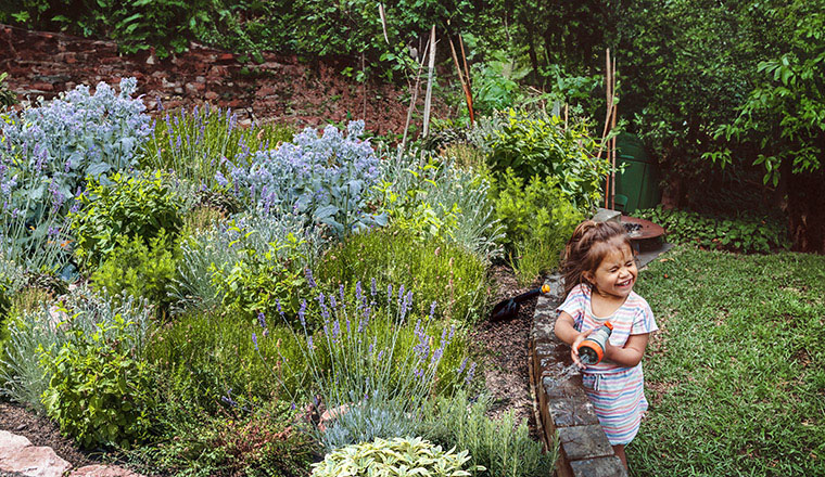 child watering garden